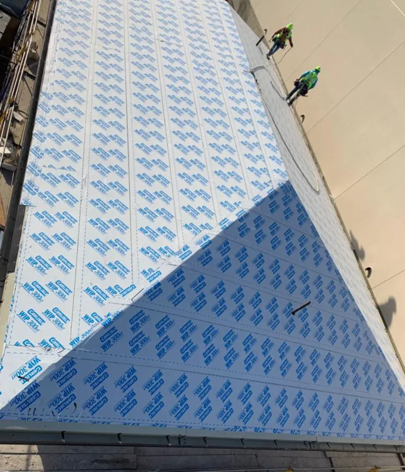 Professional roofers installing underlayment on a metal roof in Hollidaysburg